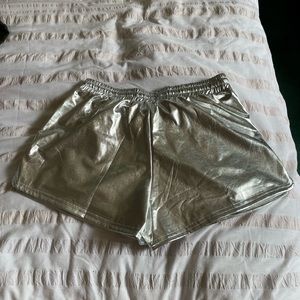 Silver shorts has pockets and string to tie